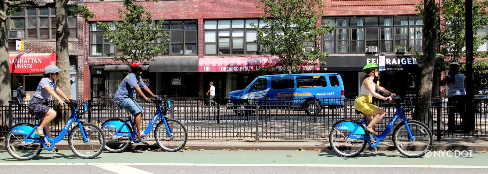 Three cyclists riding Citi Bike on Allen ST, in Manhattan