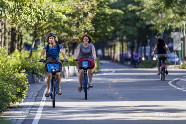 Two people riding CIti Bikes on the West Side Greenway.