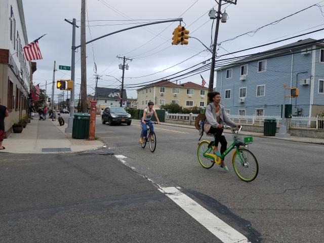 A person riding a Lime bike on the streets of the Rockaways. 