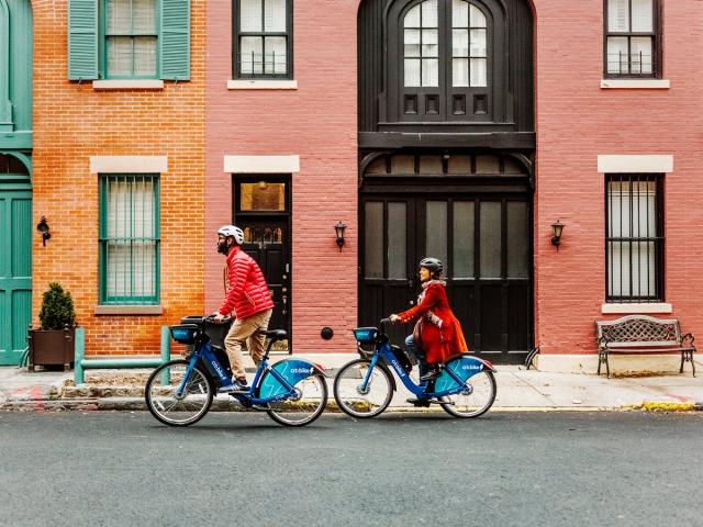 Two people riding Citi Bike e-bikes. 