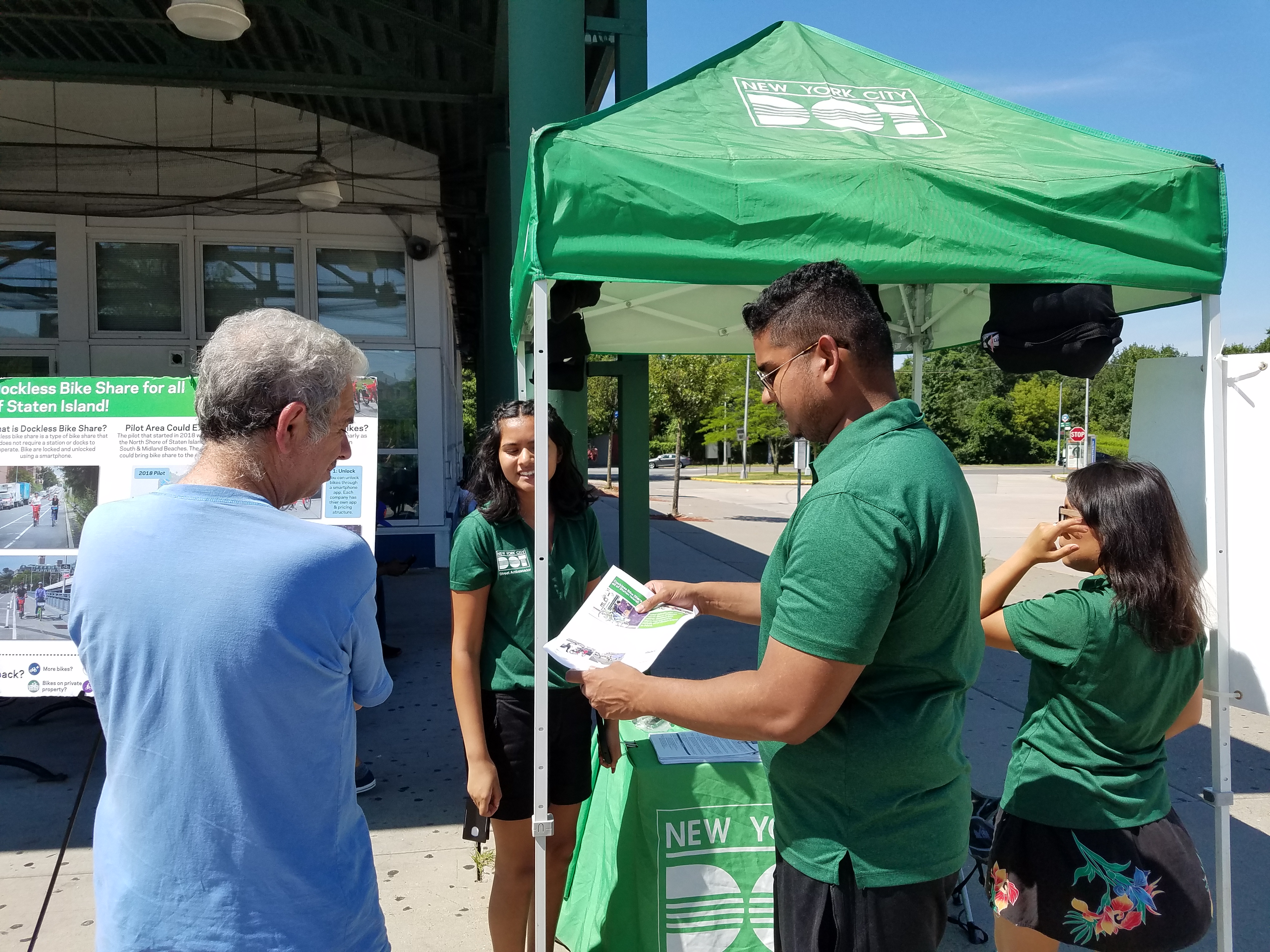 A DOT employee giving out a flyer to someone at the ETC.