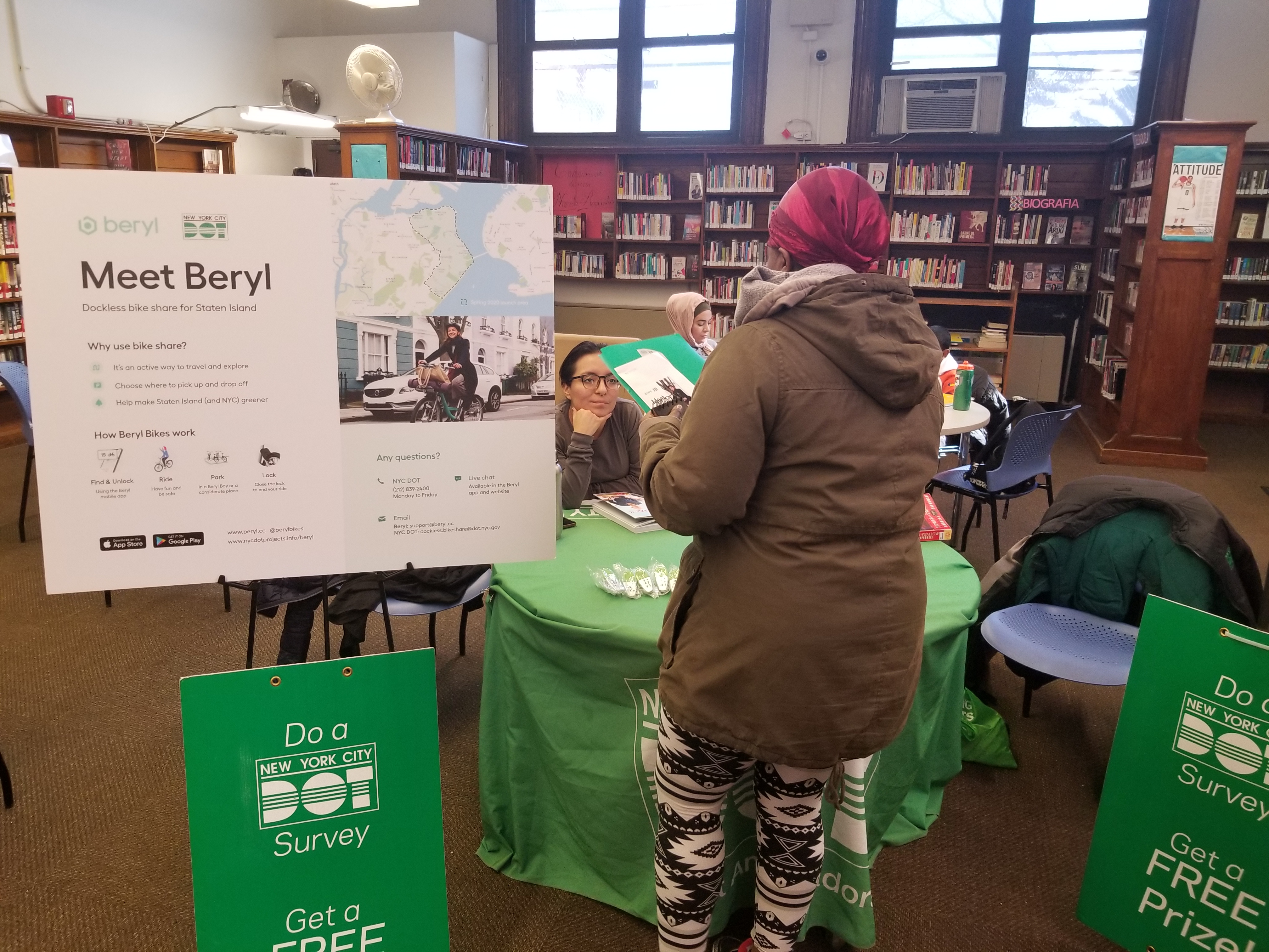 A person talking to a DOT employee about Beryl at the Port Richmond Library.