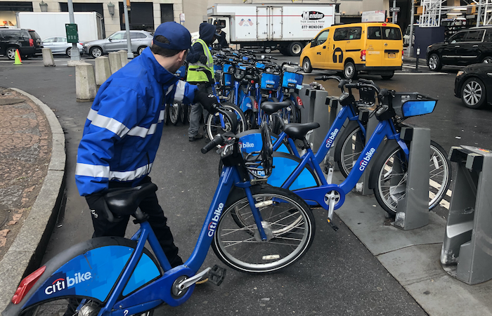 A Citi Bike employee adding Citi Bikes to a station